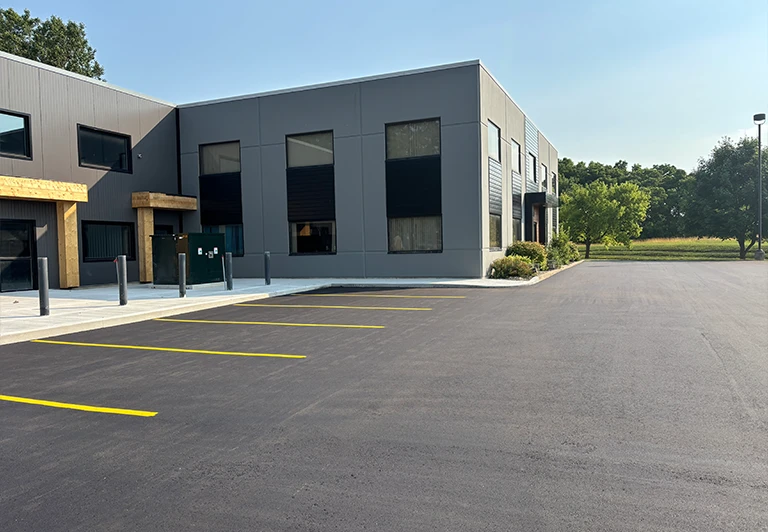 Finished residential asphalt driveway for a new custom home, showing clean edges and street-side curb appeal.