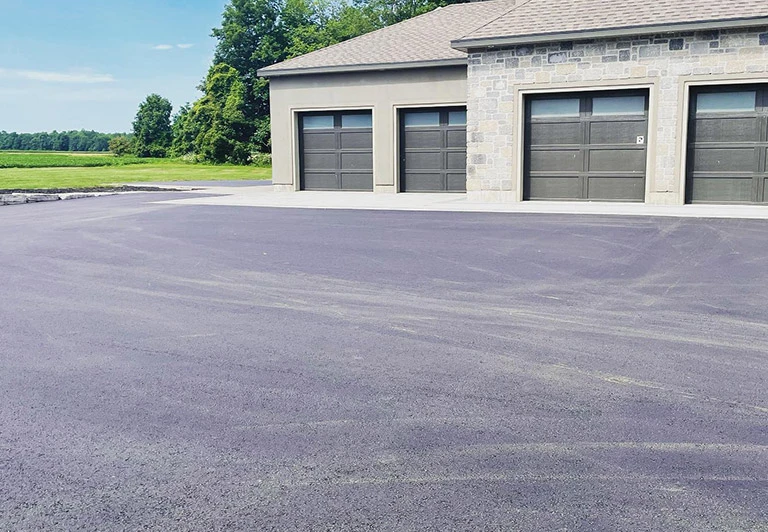 Seamless asphalt paving transition for a large residential garage in the Southwestern Ontario region.