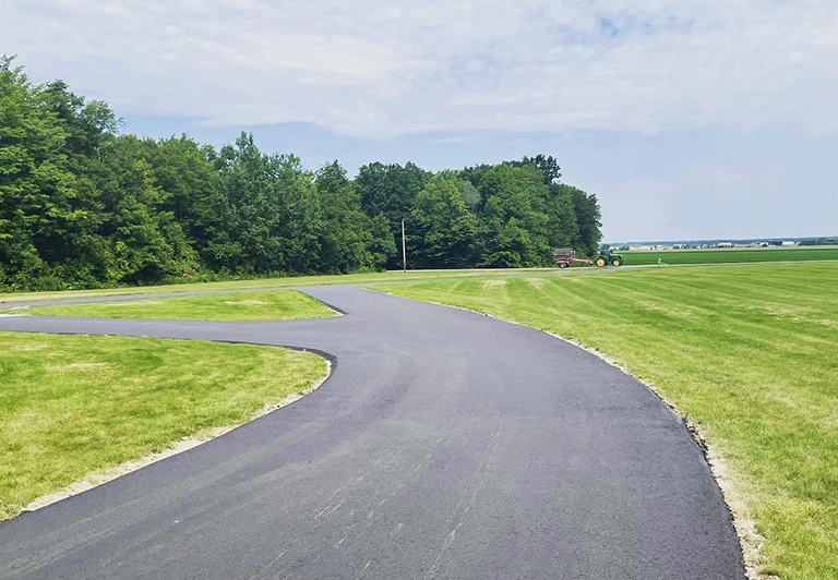 Custom asphalt farm lane with a professional Y-junction fork for a rural property in Southwestern Ontario.